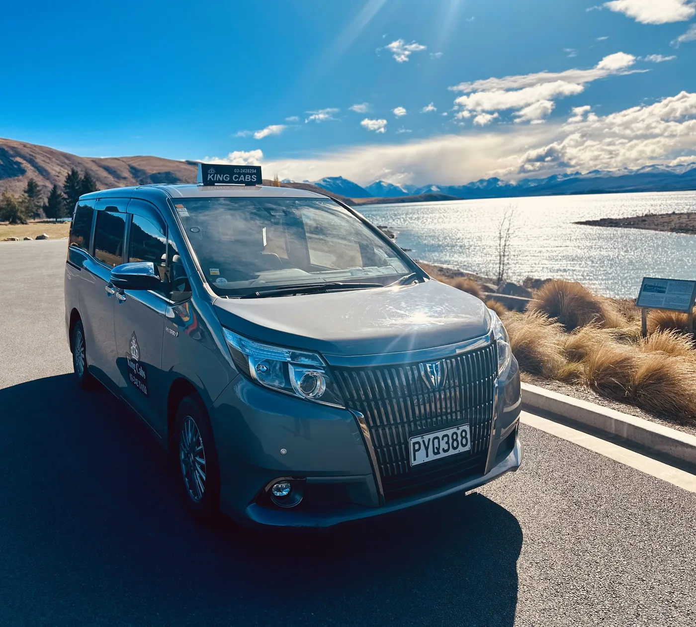 Taxi Christchurch – King Cabs 17 Real King Cabs maxi taxi beside a scenic Canterbury lake with mountains in the distance