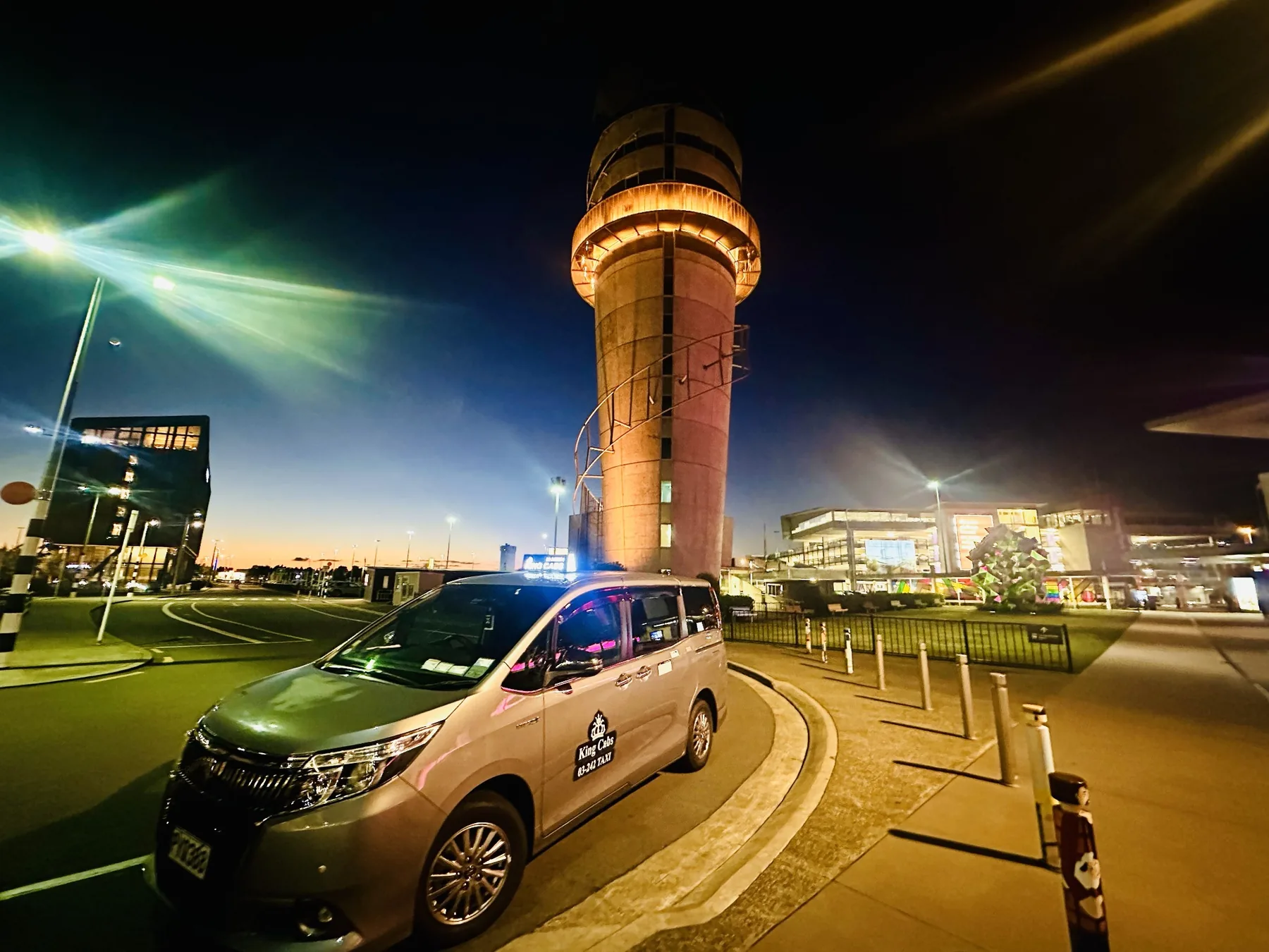 Taxi Christchurch – King Cabs 1 Real King Cabs maxi taxi outside Christchurch Airport control tower at night